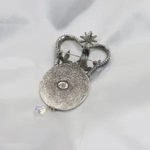 Vintage antique silver crown brooch pendant with blue rhinestones and iridescent crystal drop detail.