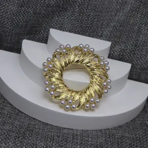 Detailansicht der vintage goldfarbenen strukturierten Kranz Brosche mit künstlichen Perlen.