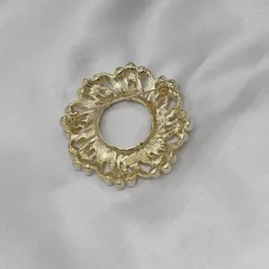 Detailansicht einer vintage goldenen Blumenkranz Brosche verziert mit künstlichen Perlen.