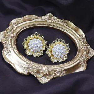 Vue en gros plan de boucles d'oreilles vintage fleurs perles dorees pour tenues elegantes.