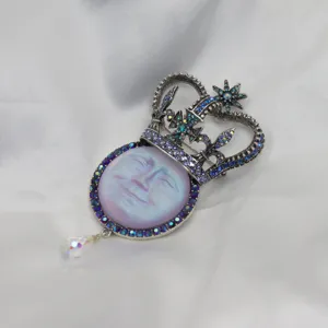 Vintage moon face crown rhinestone brooch pendant, intricate silver metal crystal jewelry detail.