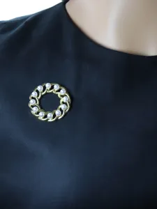 Vintage pearl chain brooch detail, elegant round hollow design with white pearls, closeup view.