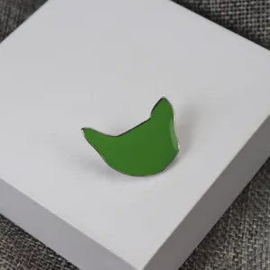 Gros plan de la broche chat en émail vert métal épingle avec surface brillante et fine.