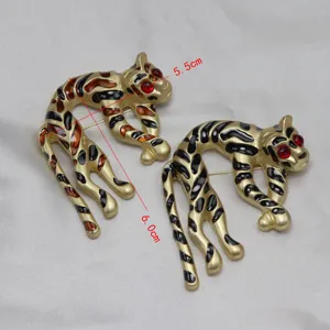 Spilla leopardata dorata vintage con macchie di smalto e occhi rossi, accessorio chic.