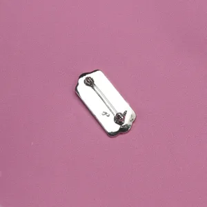 Close-up detail of the metal brooch back featuring a secure pin clasp and delicate stamped hallmark.