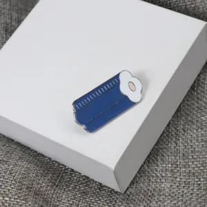 Close-up detail shot of the cute blue enamel brooch, featuring metallic trim and fine craft.