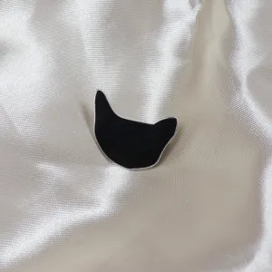 Gros plan détaillé de l'élégante broche chat en émail noir avec bordure argentée chic.
