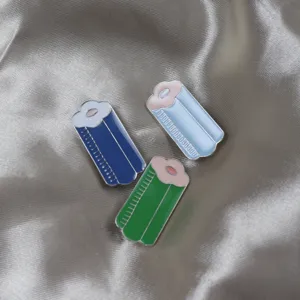 Close-up view of cute colorful hair roller enamel pins featuring detailed enamel drip glaze design.