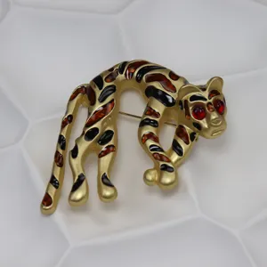 Dettaglio della spilla vintage con leopardo in smalto, elegante spilla gatto dorata.