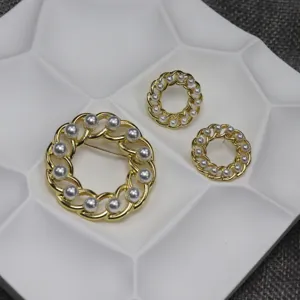 Vintage gold chain pearl brooch and stud earrings set detail shot, elegant jewelry design.