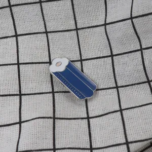 Detail view of a creative metal enamel brooch featuring a unique shape and grid background.