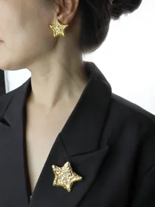 Close-up detail of vintage molten gold five-pointed star crystal brooch and earring set.
