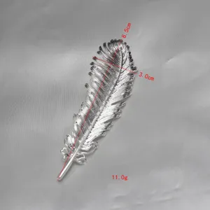 Exquisite silver metal feather brooch detailed view, elegant lapel pin clothing accessory.