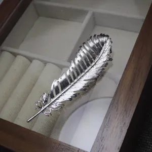 Silver feather brooch pin for women, elegant suit lapel accessory and hat clothing decor.