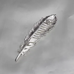 Silver feather brooch detail pin, elegant lapel accessory for suits, dresses, and hats.