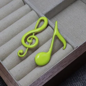 Enamel music note brooch detail, bright green treble clef pin, cute aesthetic music accessories.