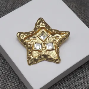 Close-up of vintage lava textured star jewelry featuring three square crystal rhinestones.