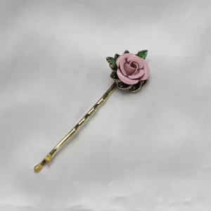 Vintage pink enamel rose flower bobby pin hair clip detail view, elegant gold metal hair accessory.