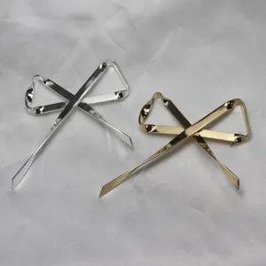 Spilla fiocco in metallo e accessorio, dettaglio elegante con finitura argento e oro.
