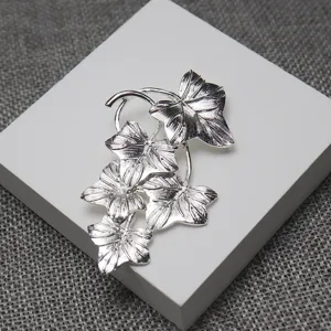 Vintage silver leaf brooch featuring detailed multi-leaf drop design for elegant clothing styling.