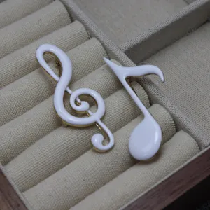 Exquisite white enamel music note brooch set featuring treble clef design for music lovers.