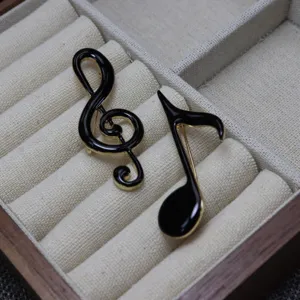 Elegant black enamel music note brooch pin set, vintage gold tone musical accessory for student.