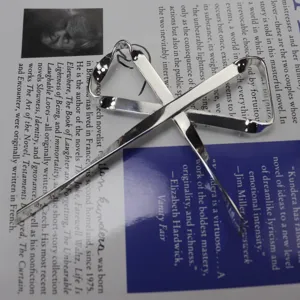 Dettaglio spilla nastro in metallo argentato, design minimalista ed elegante accessorio
