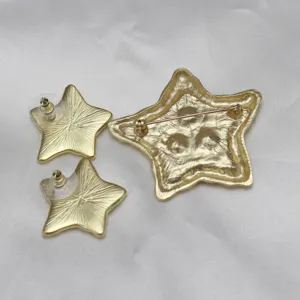 Detailed view of vintage gold lava star brooch and earrings set, showing back craftsmanship.