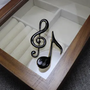 Exquisite handmade black enamel music note brooch pin, perfect for stylish apparel accessories.