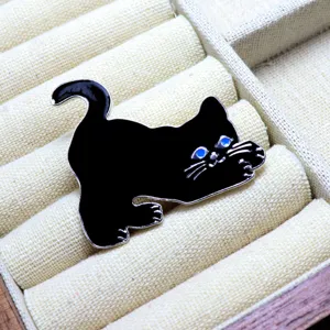 Spilla in smalto gatto nero con occhi blu, primo piano sui dettagli in metallo fini.