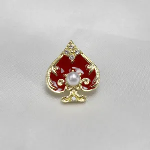 Spade-shaped pearl and rhinestone brooch featuring vibrant red enamel and gold-toned metal.