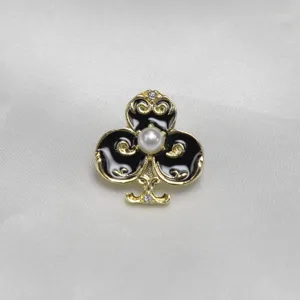 Vintage black and gold club brooch with a central white pearl and crystal decor.