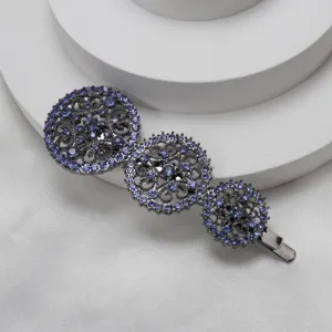 Close-up of triple circular hollow rhinestone hair clip in blue, elegant metallic finish detail.