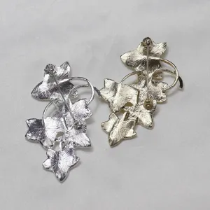Close-up view showing the secure pin back closure and metallic finish of vintage leaf brooches.