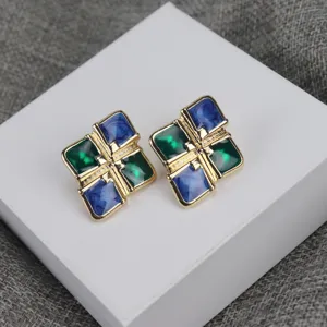 Primer plano detallado de pendientes vintage cuadrados con diseño de bloques de color azul.