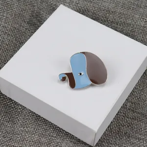 Detailed view of a cute abstract dog enamel brooch with blue and brown glaze for clothing.