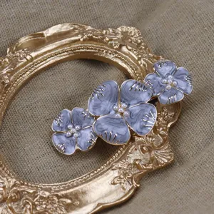 Détail de pince à cheveux fleur en émail perle vintage, design floral gris bleu élégant.