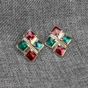Primer plano de pendientes geométricos vintage con detalles de esmalte rojo y verde brillante.