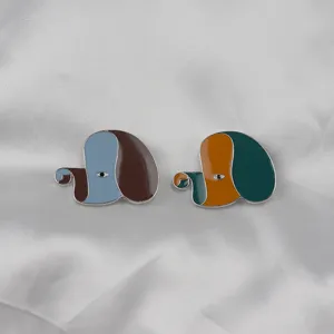 Creative abstract dog enamel brooch detail shot, exquisite metal lapel pin accessory.