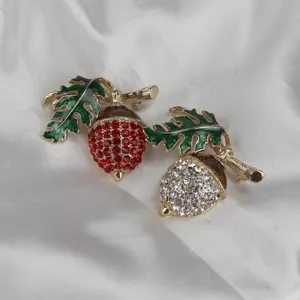Dettaglio spilla vintage a ghianda in cristallo, foglie smaltate colorate e strass scintillanti.