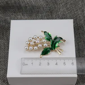 Vintage pearl enamel plant brooch detailed shot showing actual size with ruler for reference.