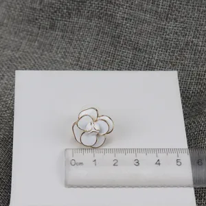 Detail shot of vintage white camellia flower enamel stud earrings with gold trim for women.