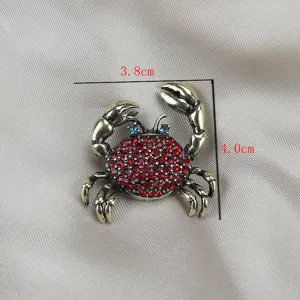 Nahaufnahme einer Vintage Krabbe Brosche mit roten Strasssteinen und blauen Augen antik bronze.