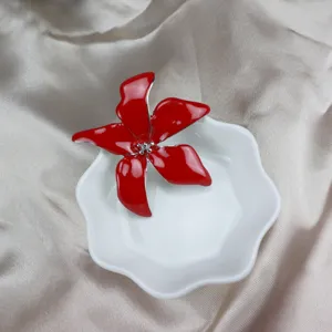 Red enamel iris flower brooch detailed view, elegant clothing accessory for women's daily wear.