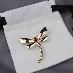 Gold tone dragonfly brooch detail, red stone accent, vintage alloy jewelry accessory.