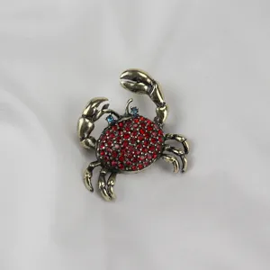 Elegante Vintage Strass Krabbe Brosche aus Antikgold Metall mit roten Zirkonsteinen.