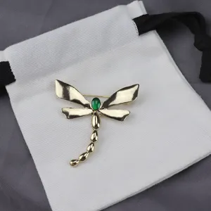 Detail shot of vintage alloy dragonfly brooch, highlighting green enamel and fine craft.