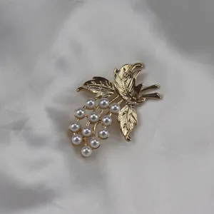 Exquisite vintage style gold-toned grape and pearl brooch detail shot, perfect apparel accessory.