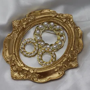 Vintage chain-link pearl brooch and earring set, elegant gold hollow jewelry accessory.