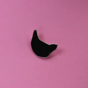Gros plan détail de broche chat émaillé noir avec une finition métallique élégante.